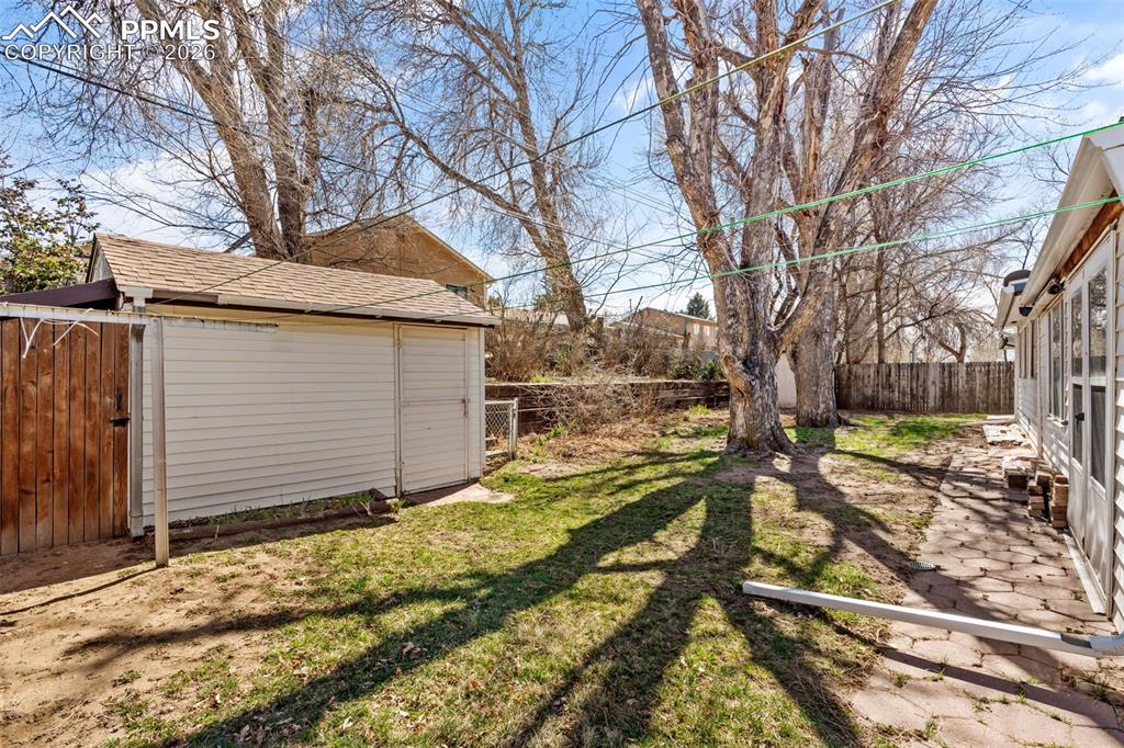 Fenced backyard with an outbuilding and a patio