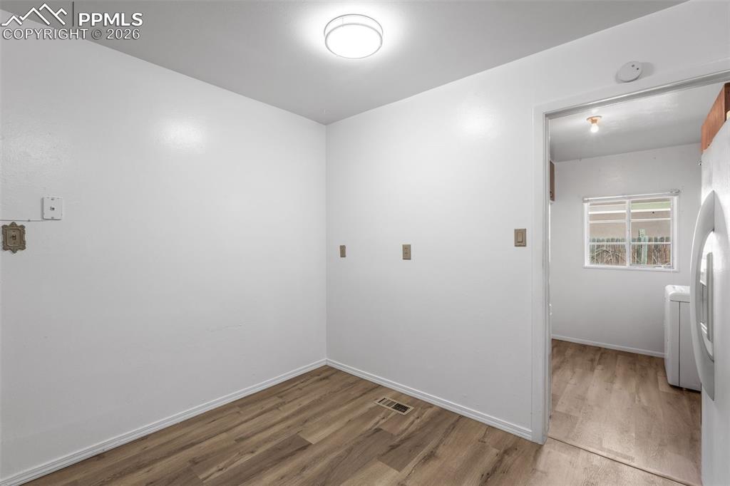 Laundry room featuring wood finished floors and washer / clothes dryer