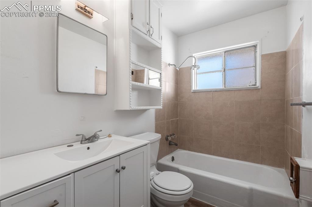 Main bathroom featuring vanity and shower / tub combination