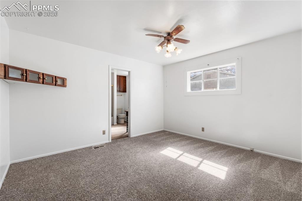 Primary bedroom featuring carpet floors and a ceiling fan