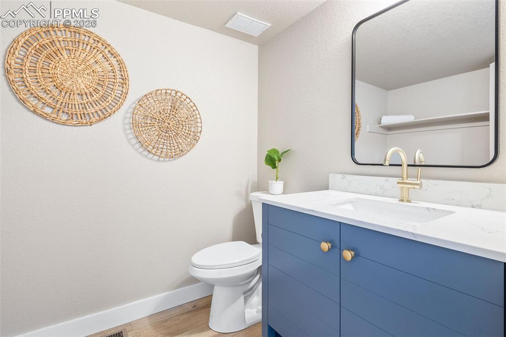 Half bathroom featuring vanity and light wood finished floors