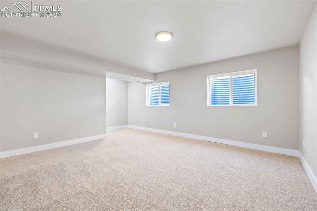 Unfurnished room with light colored carpet and baseboards