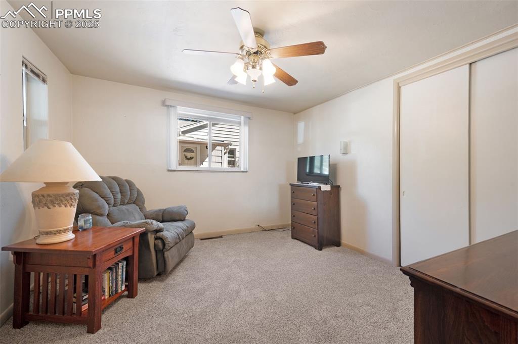 Sitting room with light colored carpet and a ceiling fan