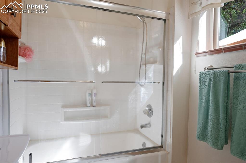 Full bath with combined bath / shower with glass door