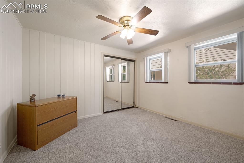 Unfurnished bedroom with carpet floors, a closet, a ceiling fan, and a textured ceiling