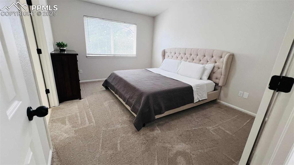 Bedroom featuring carpet flooring and baseboards