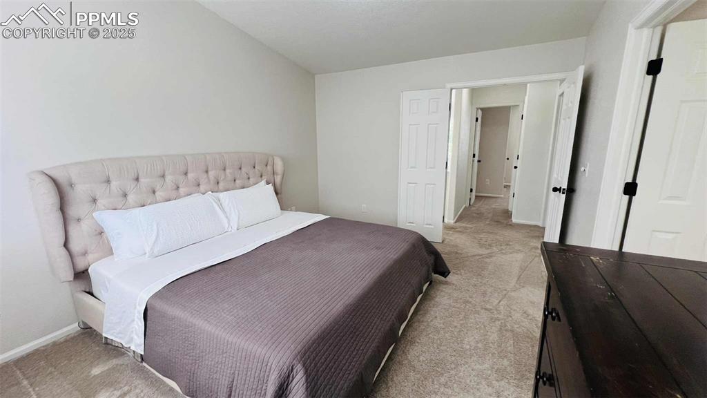 Bedroom featuring light colored carpet