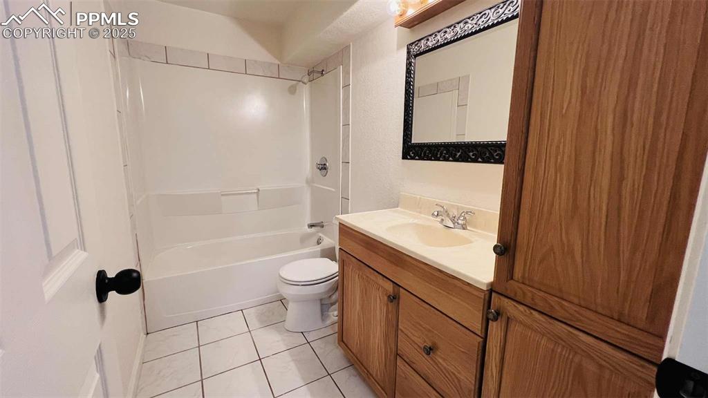 Bathroom featuring vanity, tile patterned flooring, and shower / bath combination