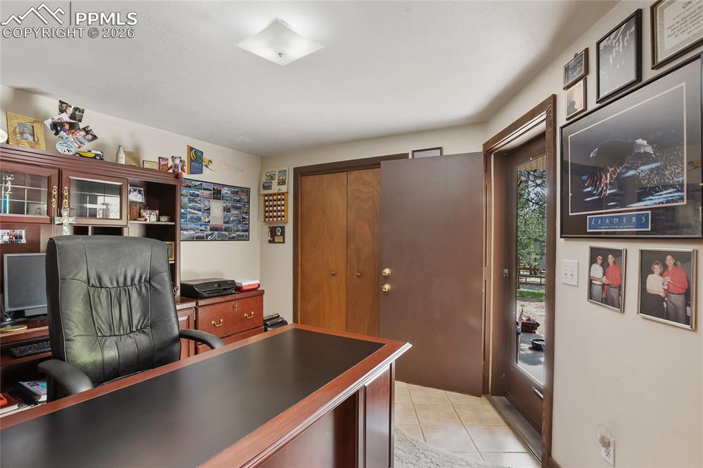 Bedroom featuring light tile floors and carpet with wooden trim!