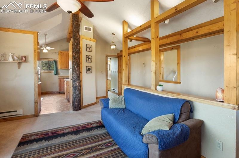 Carpeted living room with a ceiling fan, lofted ceiling, a baseboard radiator, and baseboards