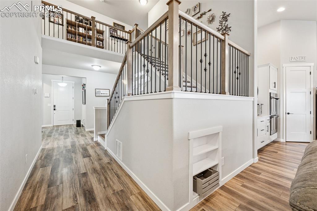 Stairs featuring a towering ceiling and wood finished floors