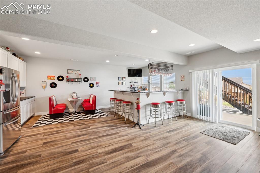 Basement kitchen/wet bar featuring stainless steel refrigerator and cute and fun; the perfect place to entertain with lots of light; walkout basement.