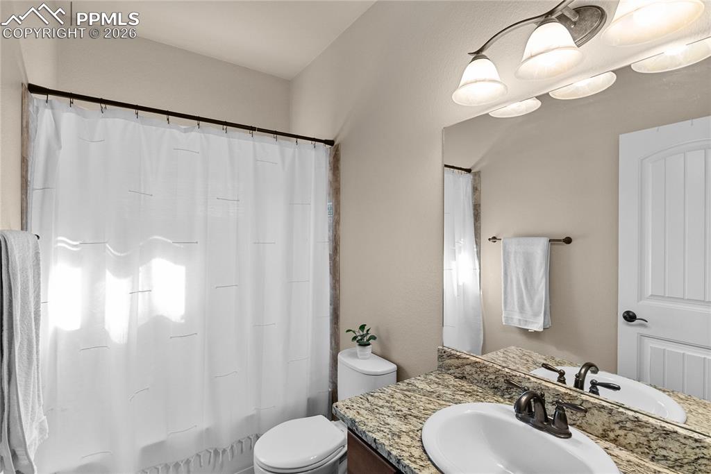 Full bathroom with granite vanity.