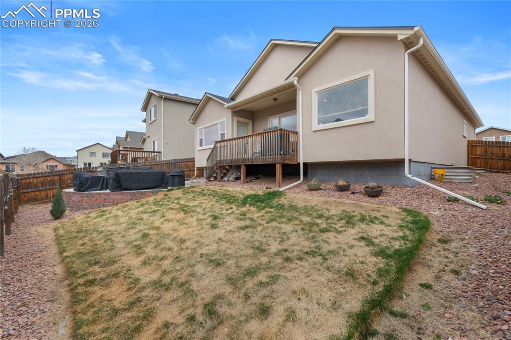 Backyard with hot tub, grill and cement patio.