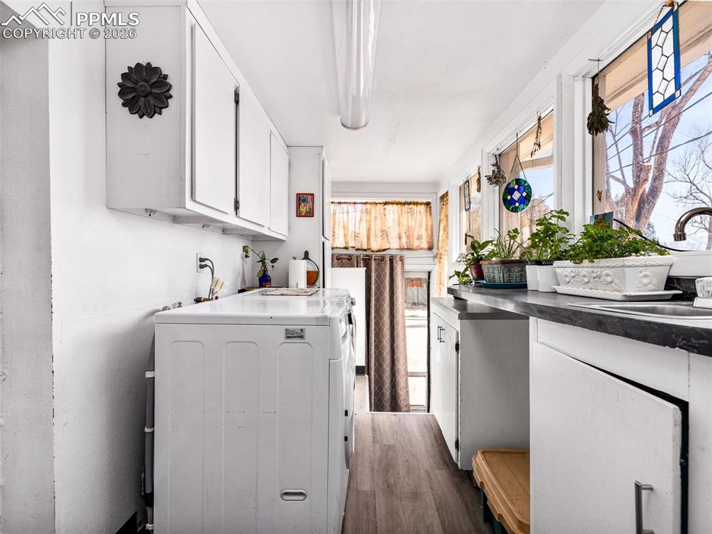 The laundry space is off the garage and the kitchen with laminate flooring and access to the back yard.