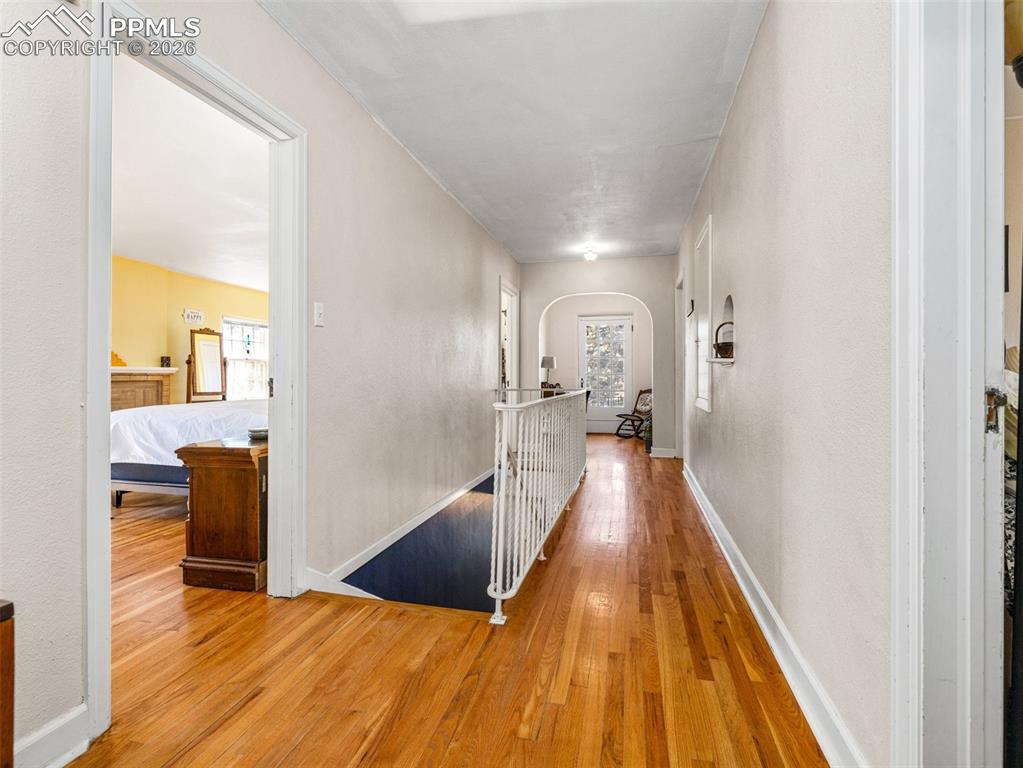 This catwalk hallway leads to 3 bedrooms and a full bath plus a Juliet balcony at the end of the hallway