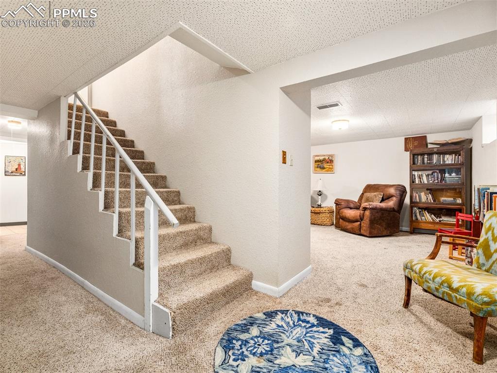 The full finished basement is mostly finished with two living spaces on either side of the stairs 