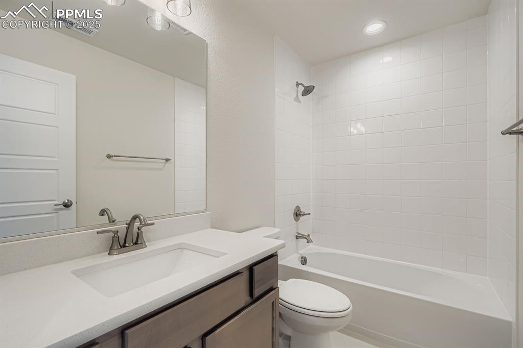 Bathroom with  shower combination, vanity, and recessed lighting