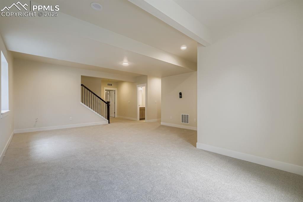 Unfurnished room featuring stairs, light carpet, and recessed lighting
