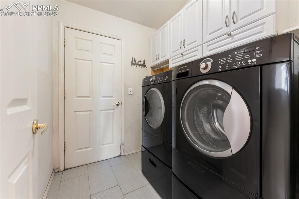 Washroom featuring washer and clothes dryer and cabinet space