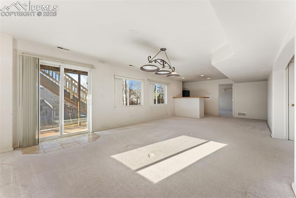 Unfurnished living room featuring carpet flooring, a chandelier, and recessed lighting