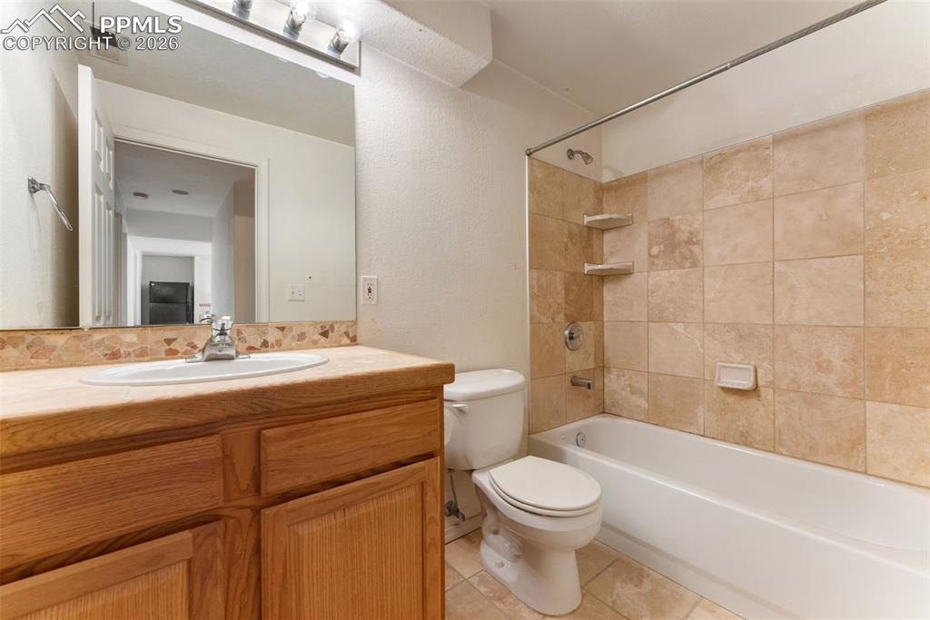 Full bathroom featuring  shower combination, vanity, and light tile patterned floors