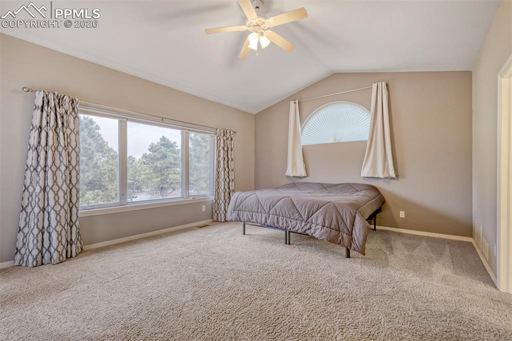 Master bedroom featuring carpet, ceiling fan, and ensuite bathroom, walk in closet and walkout to deck