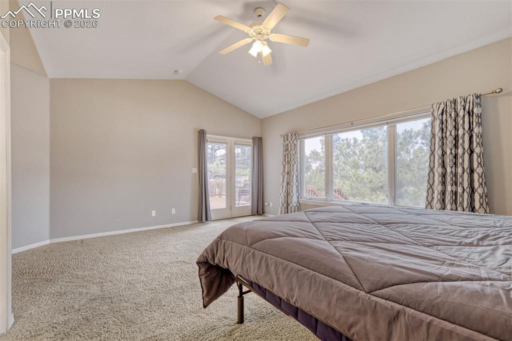 Master bedroom featuring carpet, ceiling fan, and ensuite bathroom, walk in closet and walkout to deck