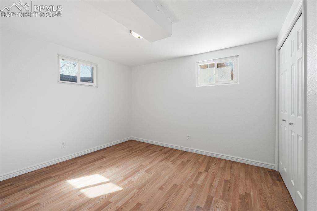 Spacious basement bedroom with plank flooring