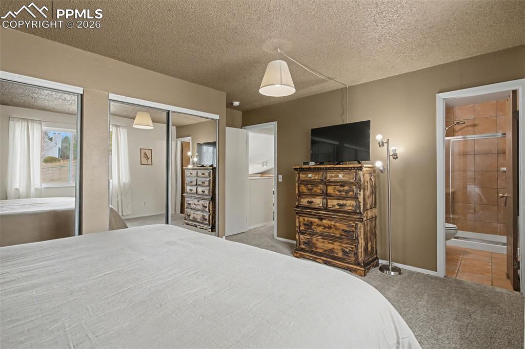 Primary bedroom with view into adjoining bathroom