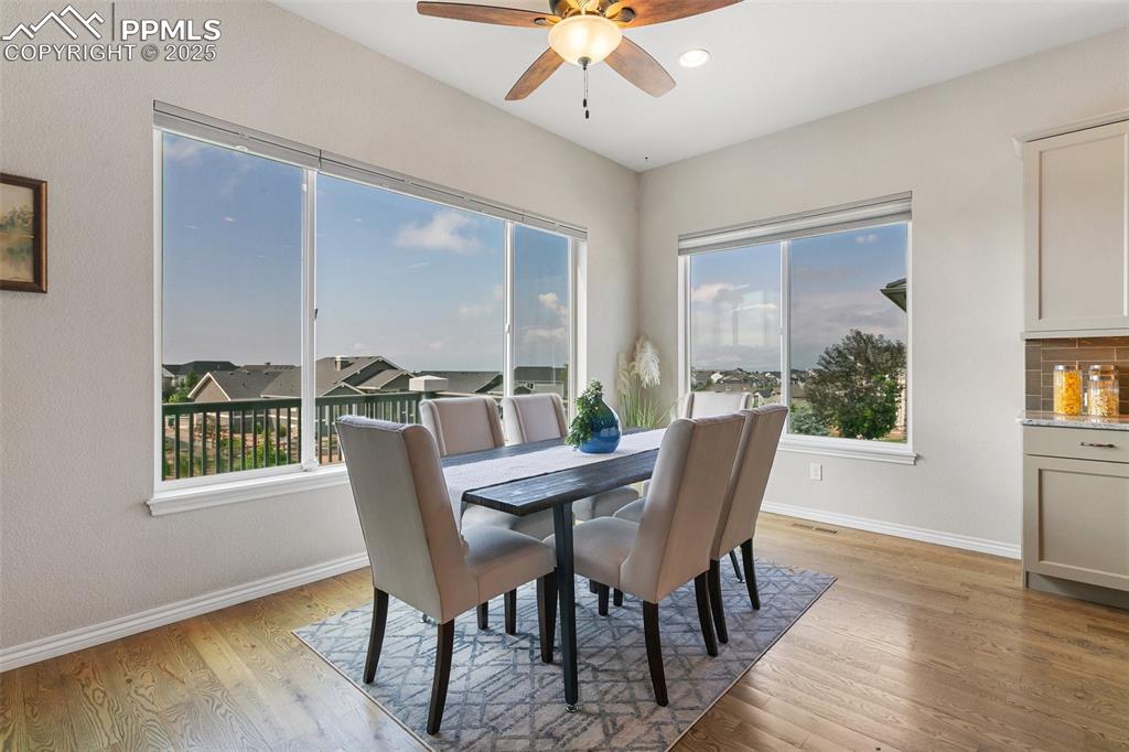 Dining room with plenty of natural light, light wood-style floors, and ceiling fan