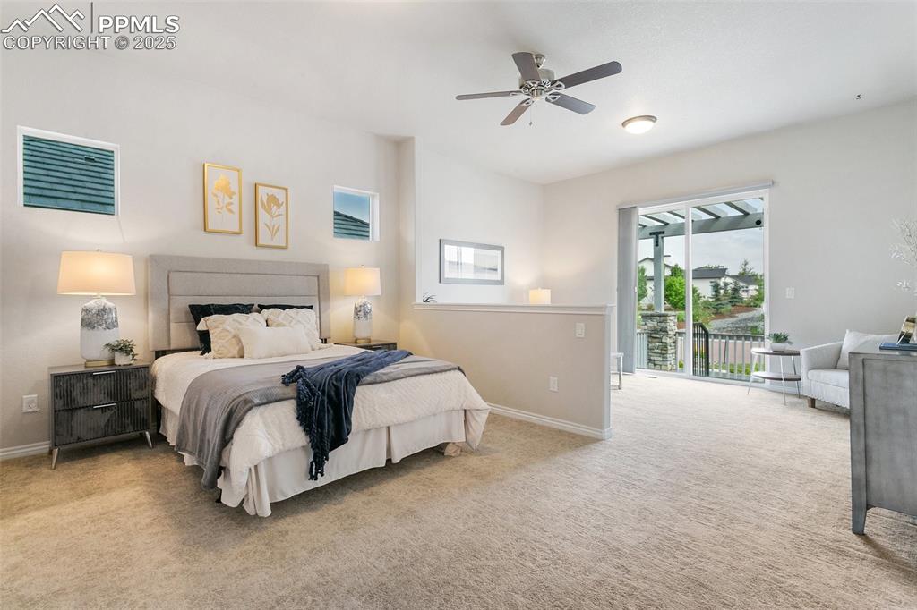 Bedroom with access to exterior, carpet flooring, and ceiling fan
