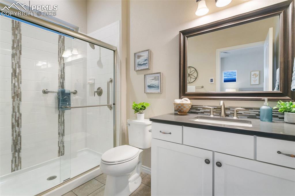 Bathroom featuring vanity, a stall shower, and tile patterned floors
