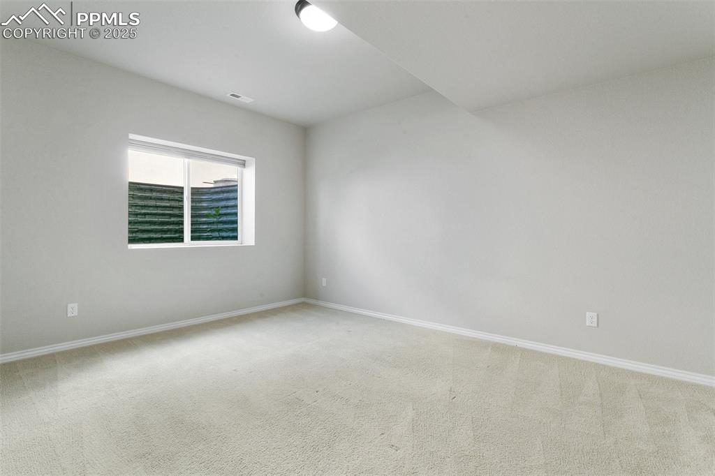 Carpeted spare room with baseboards
