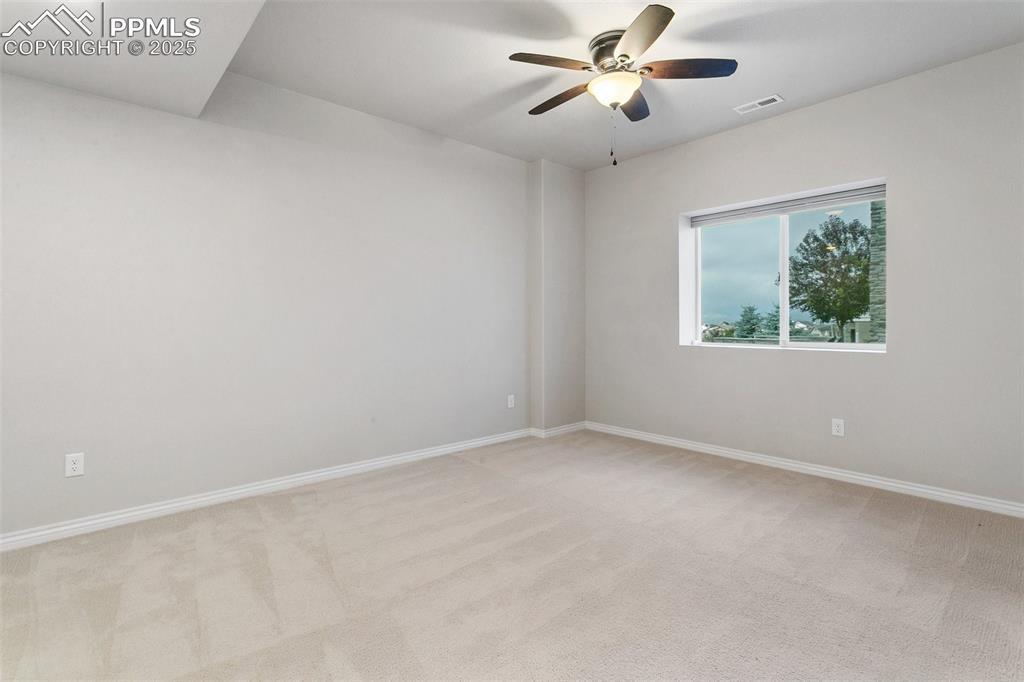 Empty room featuring light carpet and ceiling fan