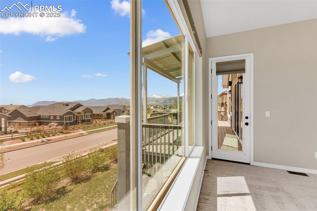 Unfurnished sunroom featuring a residential view and a mountain view