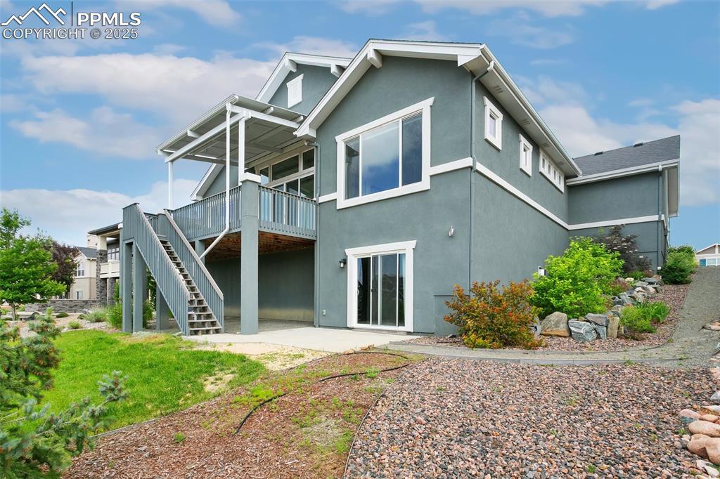 Back of house with a patio, a deck, and stucco siding