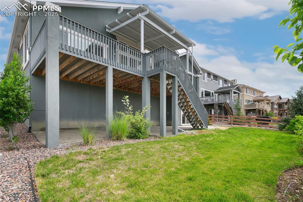 Rear view of house with a deck, stairs, and stucco siding