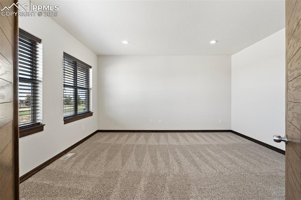 Carpeted office with French doors and recessed lighting