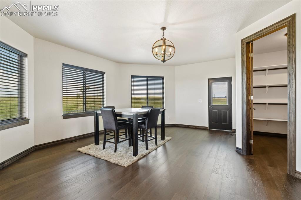 Eat-in kitchen with a chandelier and dark wood floors