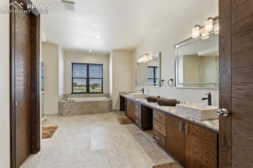 Main level Primary bathroom with double vanity and a garden tub