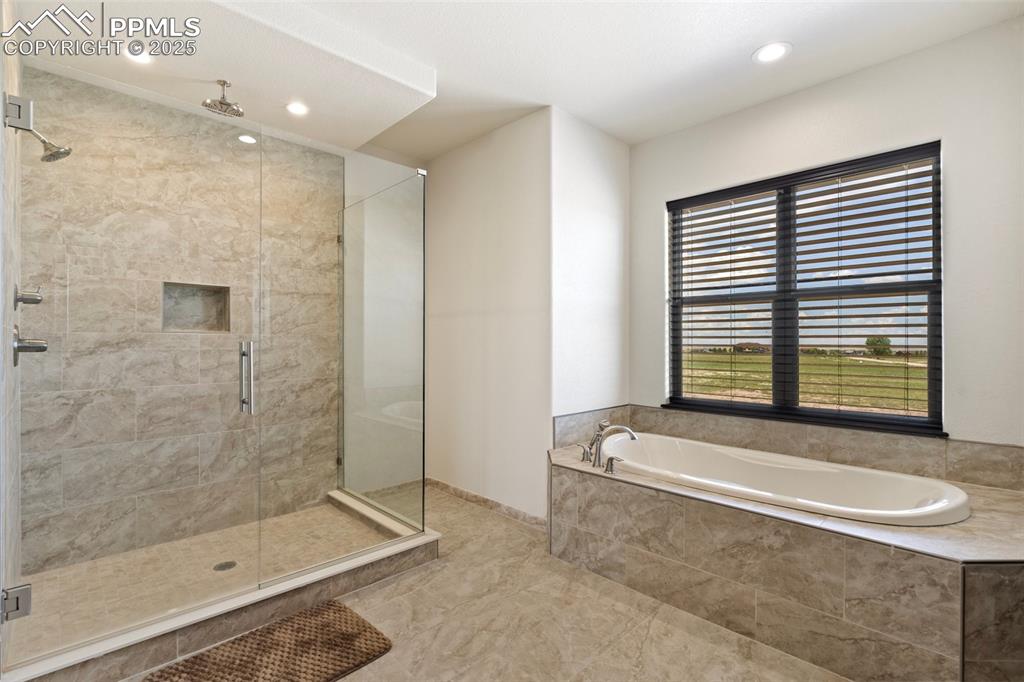 Main level Primary bathroom featuring a stall shower, a bath, and recessed lighting