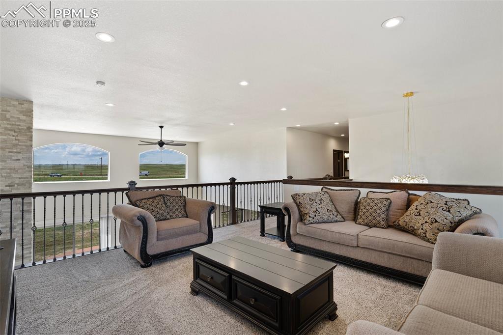 Loft area with light carpet, a ceiling fan, and recessed lighting