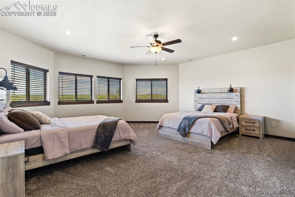 Carpeted bedroom with recessed lighting and ceiling fan