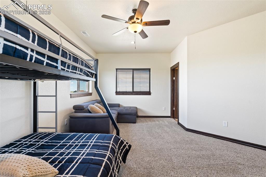 Carpeted bedroom with baseboards and a ceiling fan