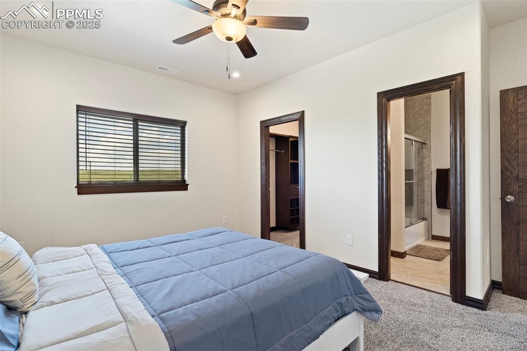 Bedroom with light colored carpet, recessed lighting, a ceiling fan, and a spacious closet