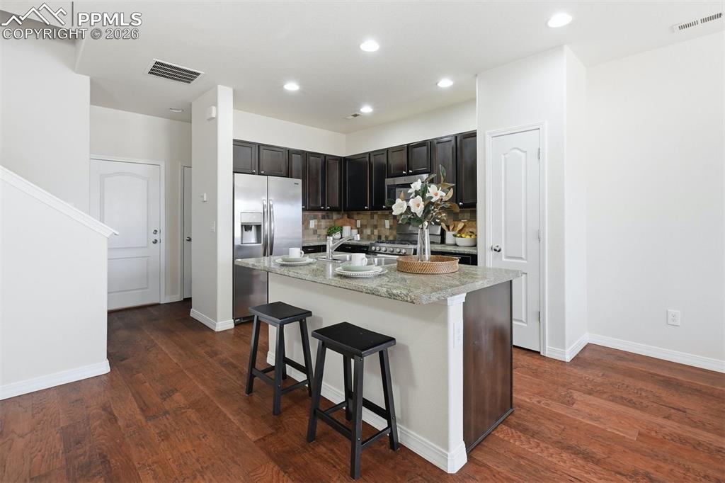 Kitchen showcases generous island with seating, ideal for morning coffee, homework time, or entertaining.