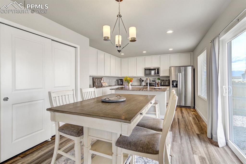 Dining space featuring light wood-style floors, recessed lighting, and a chandelier