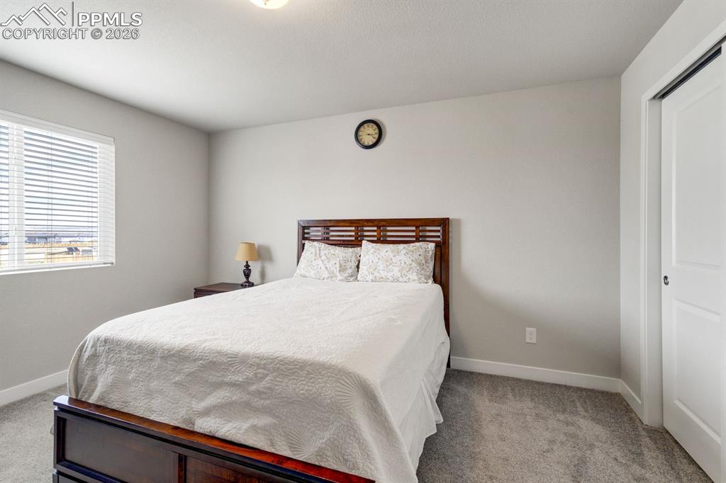 Bedroom featuring light carpet and a closet