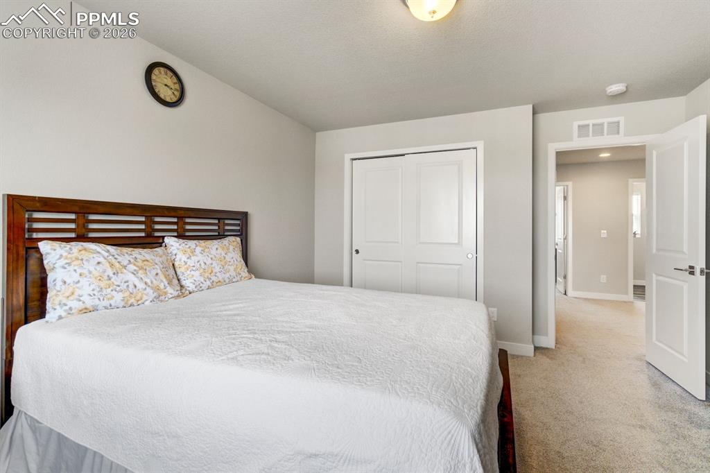 Bedroom with light carpet and a closet